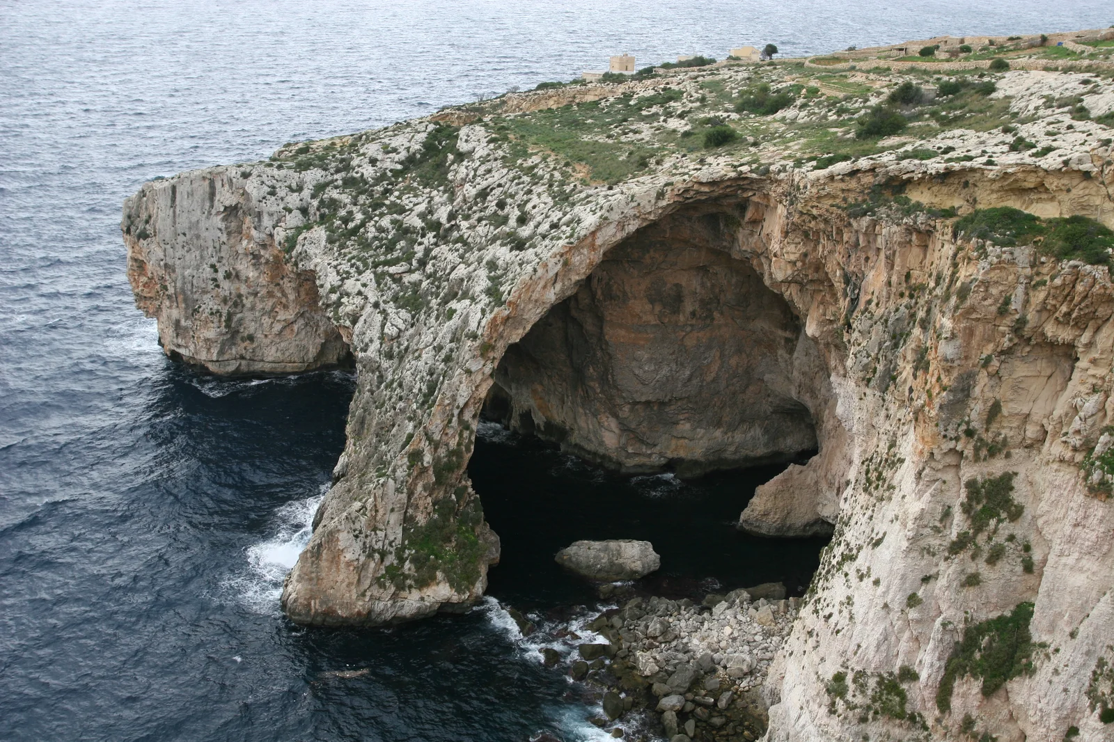Cổng vòm đá tự nhiên và làn nước biển xanh ngọc bích phát sáng kỳ ảo tại hang Blue Grotto phía nam Malta