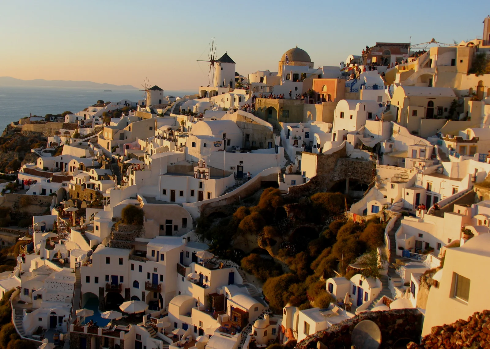 Hoàng hôn buông xuống cối xay gió và những ngôi nhà trắng vách đá tại làng Oia Santorini