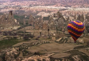 Toàn cảnh khinh khí cầu rực rỡ sắc màu bay lượn trên thung lũng đá núi lửa Cappadocia lúc bình minh Thổ Nhĩ Kỳ