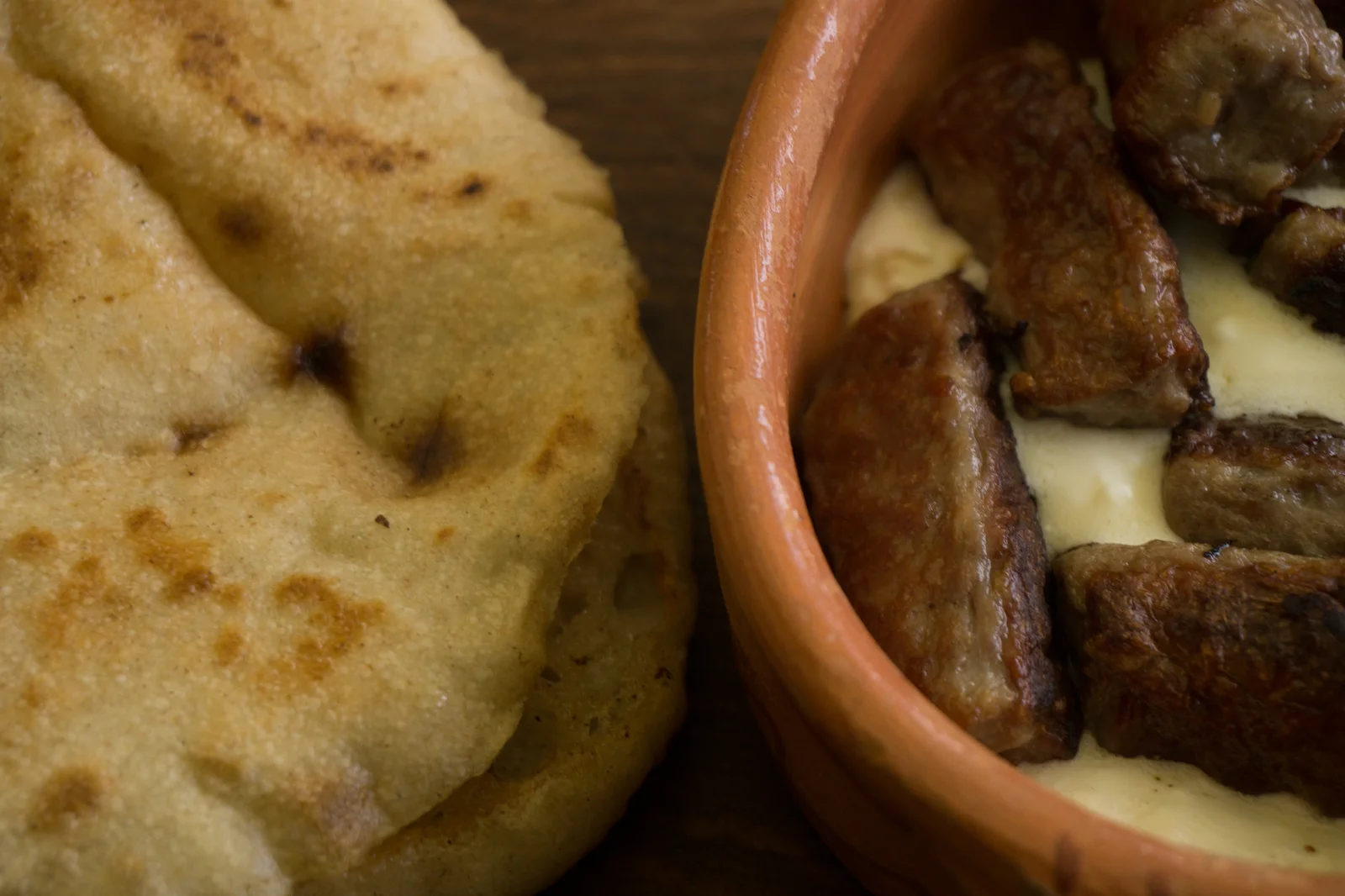 Đĩa thịt nướng thơm lừng Ćevapi kẹp bánh mì truyền thống Somun và xốt kem béo ngậy Kajmak vùng Balkan