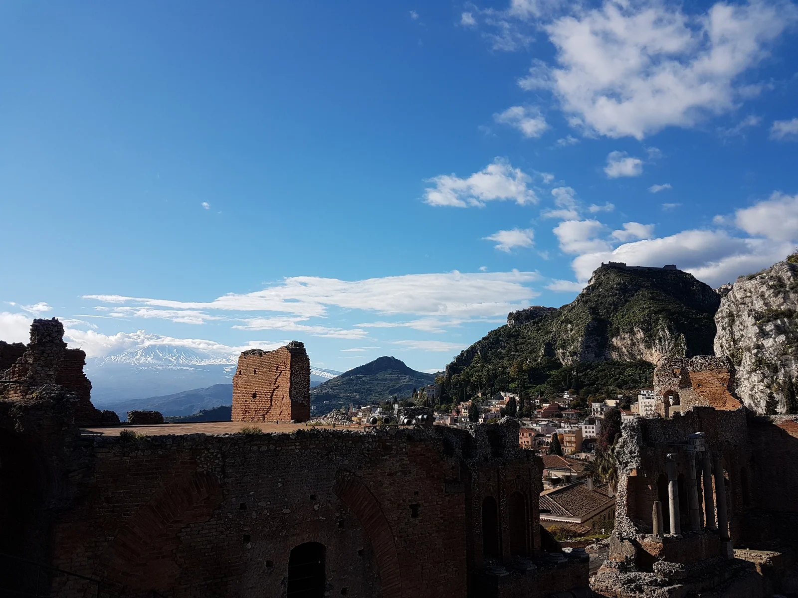 Tàn tích Nhà hát Hy Lạp cổ đại Teatro Antico di Taormina với hậu cảnh là đỉnh núi lửa Etna hùng vĩ tại đảo Sicily Ý