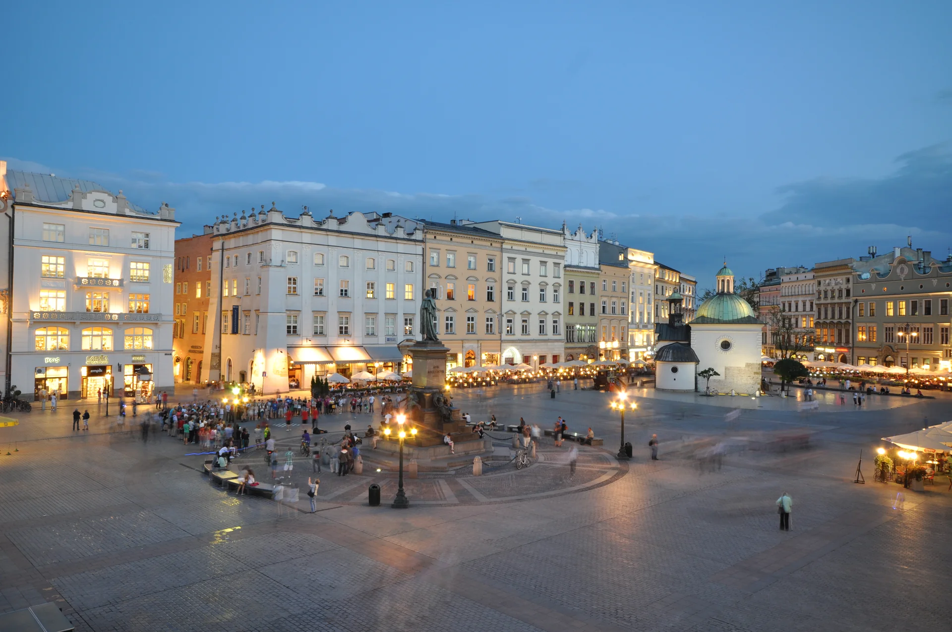 Quảng trường chợ chính Rynek Glowny rộng lớn tại cố đô Krakow Ba Lan lung linh ánh đèn lúc hoàng hôn buông xuống