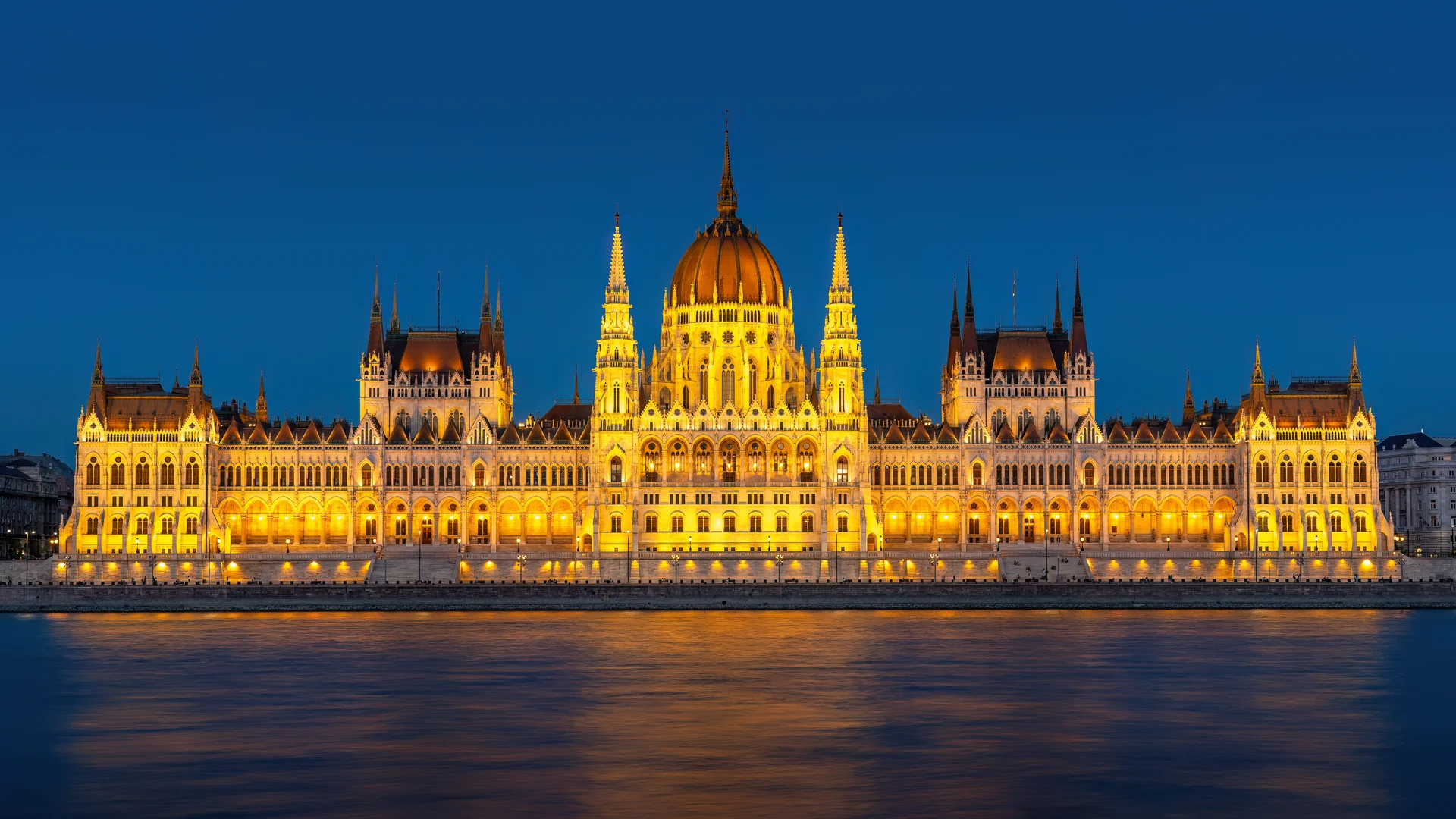 Tòa nhà Quốc hội Hungary tráng lệ phong cách Gothic Revival rực sáng trong đêm soi bóng dòng sông Danube tại thủ đô Budapest