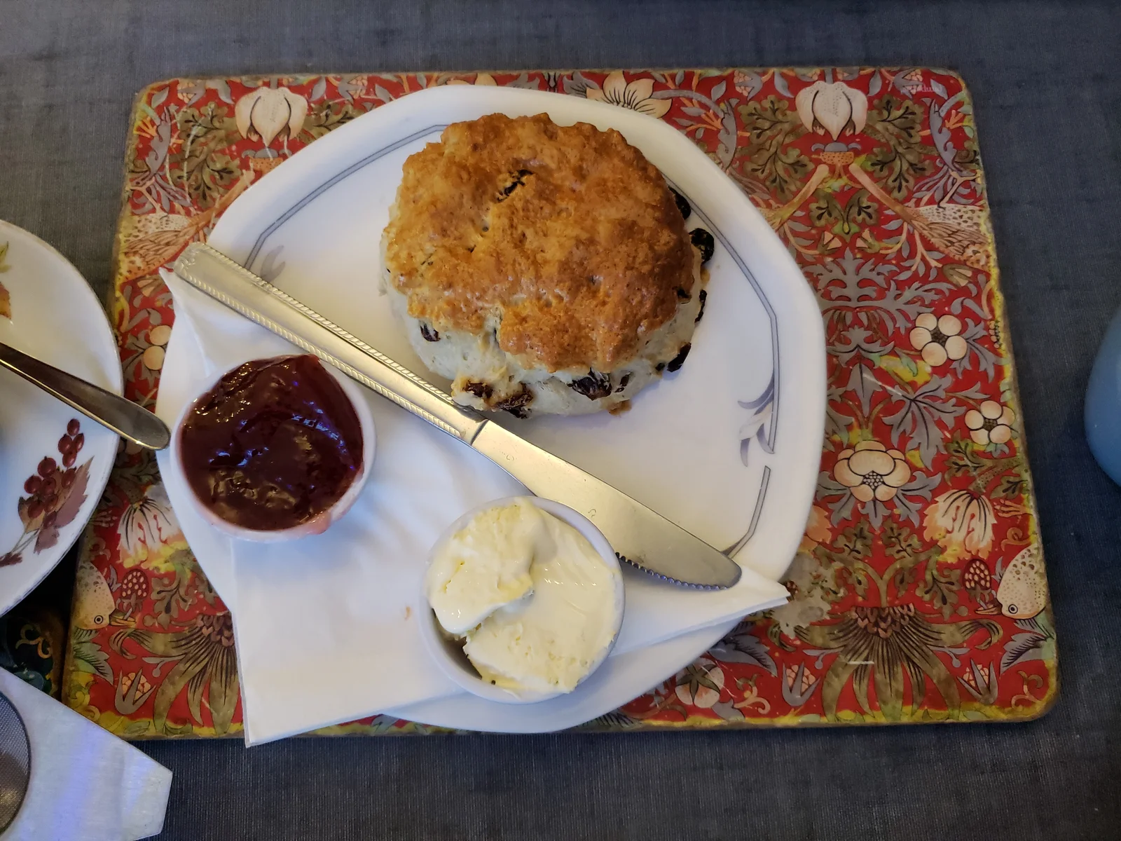 Bàn tiệc trà chiều kiểu Anh truyền thống với bánh scone nướng vàng ruộm kem đông Clotted cream béo ngậy và mứt dâu tây