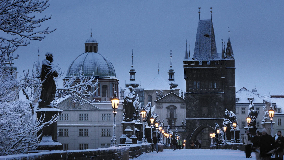 Cầu Charles lịch sử bắc qua sông Vltava tại Praha Séc phủ tuyết trắng với các tượng thánh cổ kính