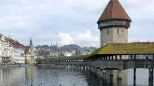 Cây cầu gỗ có mái che Kapellbrücke thế kỷ 14 ngập tràn hoa dạ yến thảo bắc qua dòng sông Reuss ở Lucerne Thụy Sĩ