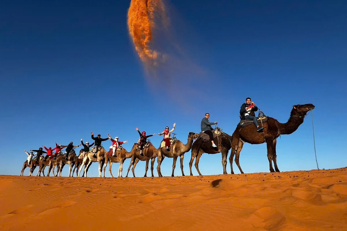 Hình ảnh thực tế đoàn khách HanoiSkyTours cưỡi lạc đà băng qua đồi cát sa mạc Sahara tại Merzouga, Maroc