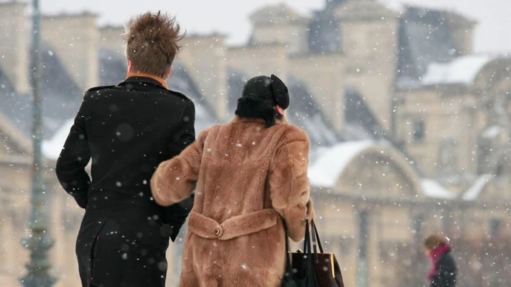 Du khách mặc áo khoác giữ nhiệt, khăn quàng cổ và găng tay dạo bước trong công viên tuyết Paris