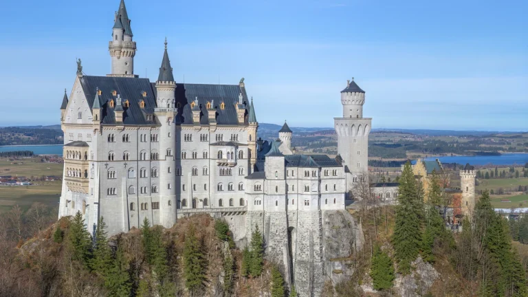Toàn cảnh Lâu đài Neuschwanstein với các tháp nhọn cổ tích ngự trên đỉnh đồi rừng thông hùng vĩ dãy Alps