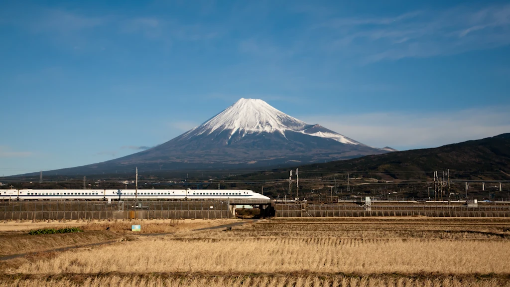 Đoàn tàu siêu tốc Shinkansen hiện đại chạy qua cánh đồng chè xanh ngát dưới chân núi Phú Sĩ hùng vĩ